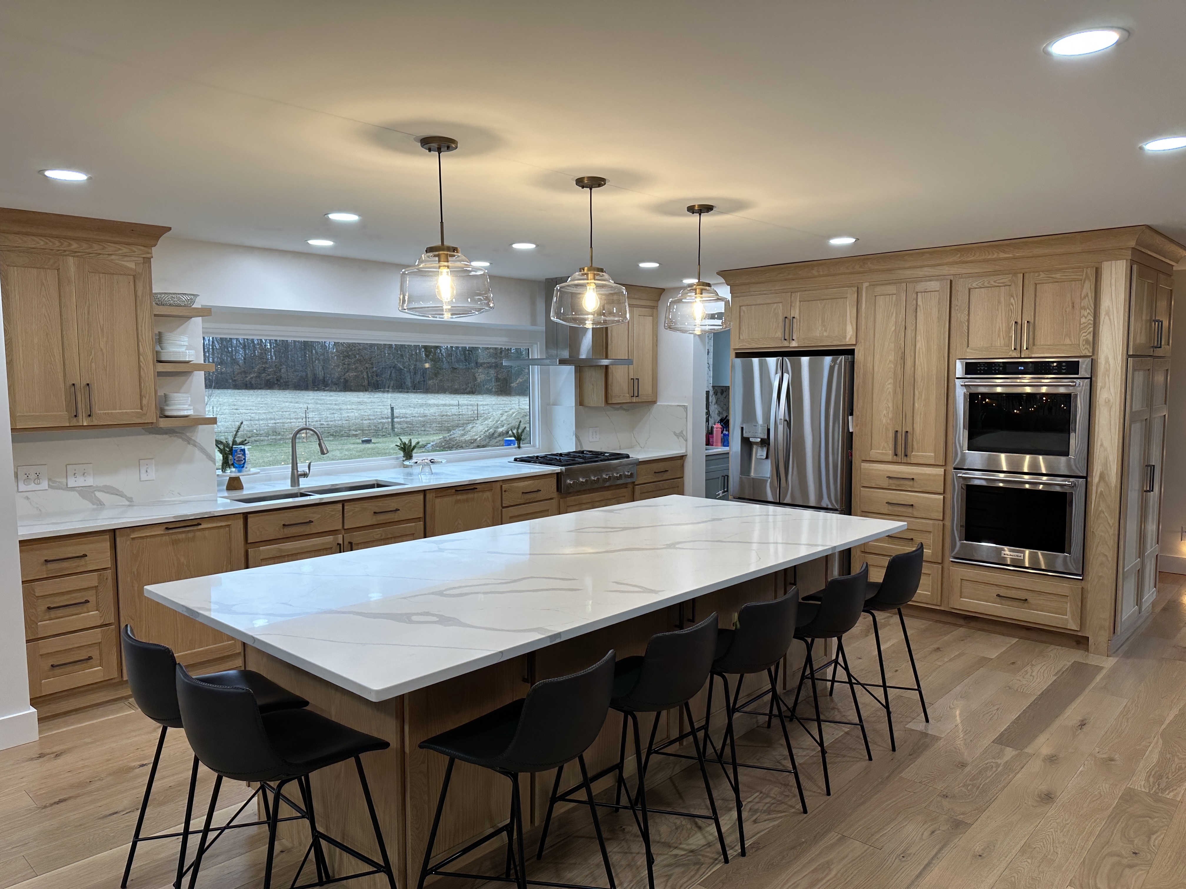 Oak kitchen with an oversized waterfall island by Resolute Construction and Remodel